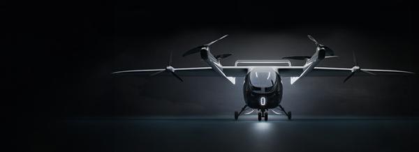 A futuristic electric vertical take-off aeroplane with four rotors, shown from the front on a dark background.