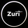 Zuri logo with an aeroplane icon over the letter i, inside a glowing white circle on a black background.